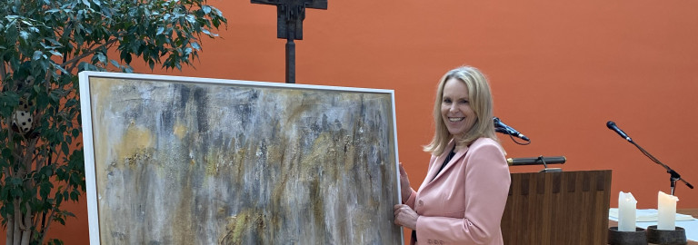 Die Künstlerin Irene Lösel steht vor einem abstraktem Kunstwerk